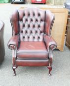 A Ox-Blood Leather Wingback Armchair on Queen Arm legs