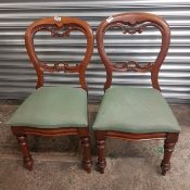 A pair of mahogany balloon back dining chairs with turned front supports