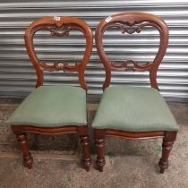 A pair of mahogany balloon back dining chairs with turned front supports