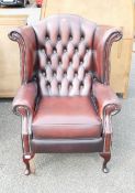 An Ox-blood Chesterfield Wingback Armchair on Queen Anne Legs