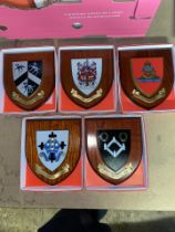 A collection of boxed wooden heraldic shields each with hand painted raised shield, including