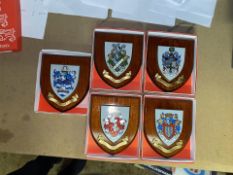 A collection of boxed wooden heraldic shields each with hand painted raised shield, including