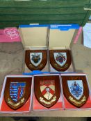 A collection of boxed wooden heraldic shields each with hand painted raised shield, including West