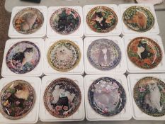 A collection of decorative wall plates, Danbury Mint 'Cats Among the Flowers' series by Lesley