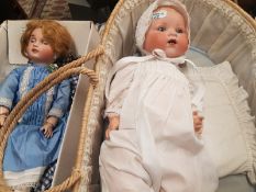 Two vintage headed porcelain Dolls one marked AM Germany in wicker cot and one marked Limoges (2)