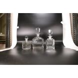 Three Glass Stoppered Bottles; to include two art deco large perfume bottles together with a smaller