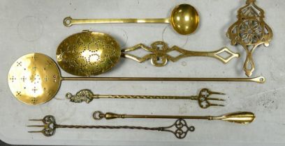 A collection of Brass items to include toasting forks, chestnut toaster, trivet etc
