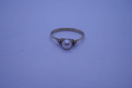 Pretty 9ct yellow gold dress ring with central pearl flanked 3 small diamonds to each side