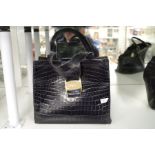 Salvatore Ferragamo; A black leather crocodile style handbag with gilt clasp