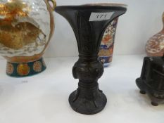 An oriental bronze vase having flared rim and a bronze two handled censer having pierced lid
