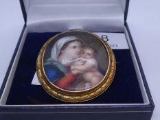 Yellow metal oval mounted brooch with painted panel depicting mother and child