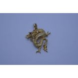 14K yellow gold pendant in the form of a dragon with red stem set eye, marked 14K, approx 2.5cm, 2.6
