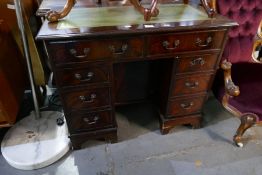 A reproduction mahogany kneehole desk