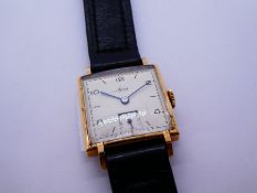 A 9ct gold head Avia wristwatch with a black strap. The face having numerical and baton hour markers