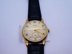 A 9ct gold Rotary wristwatch with a black leather strap. Alternating numerical and baton hour marks,