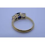 Yellow gold dress ring, possibly 18ct set with central blue stone flanked clear gemstones, previousl