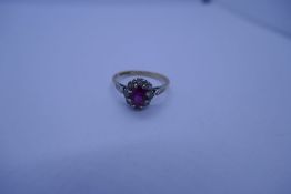 9ct yellow gold ruby and paste set cluster ring with central oval mixed cut ruby surrounded clear st