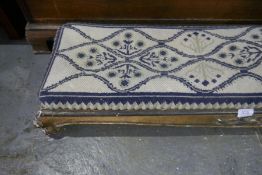 An antique gilt wood long foot stool having carved decoration