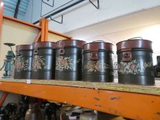 A set of five graduated canisters having painted floral decoration and a metal figure