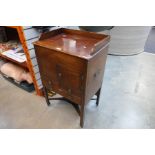 A Georgian mahogany commode having gallery top with drawers and cupboard below