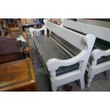 A Victorian style grey painted hall bench having scroll arms and turned front legs