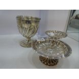 A Georgian silver sweet cup having a handle. Half-reeded body and decorative circular foot. Hallmark