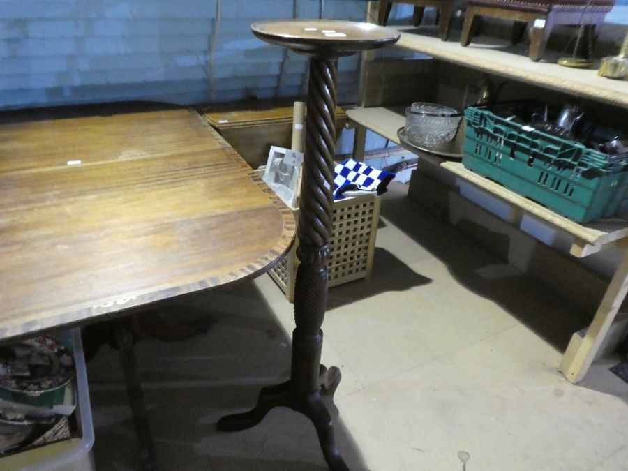 An old mahogany torchere having twisted column