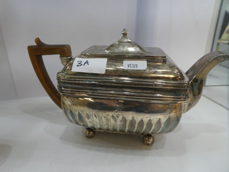 A Georgian silver rectangular teapot having half gadrooned body, four ball feet and rectangular hing