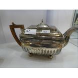 A Georgian silver rectangular teapot having half gadrooned body, four ball feet and rectangular hing