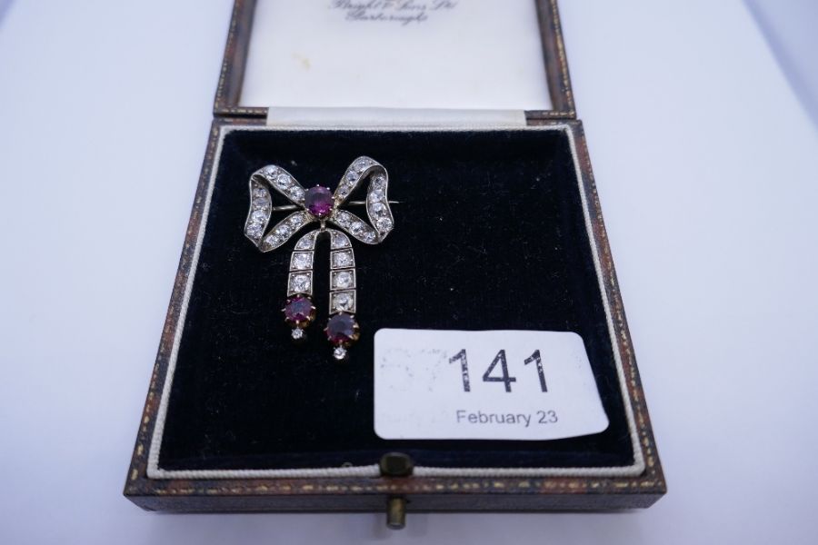 An impressive Victorian ruby and diamond brooch, with form of a bow with central round cut ruby surr