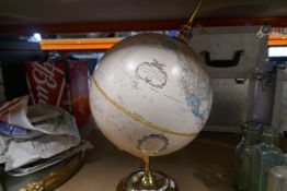 A modern globe on a brass and wood stand