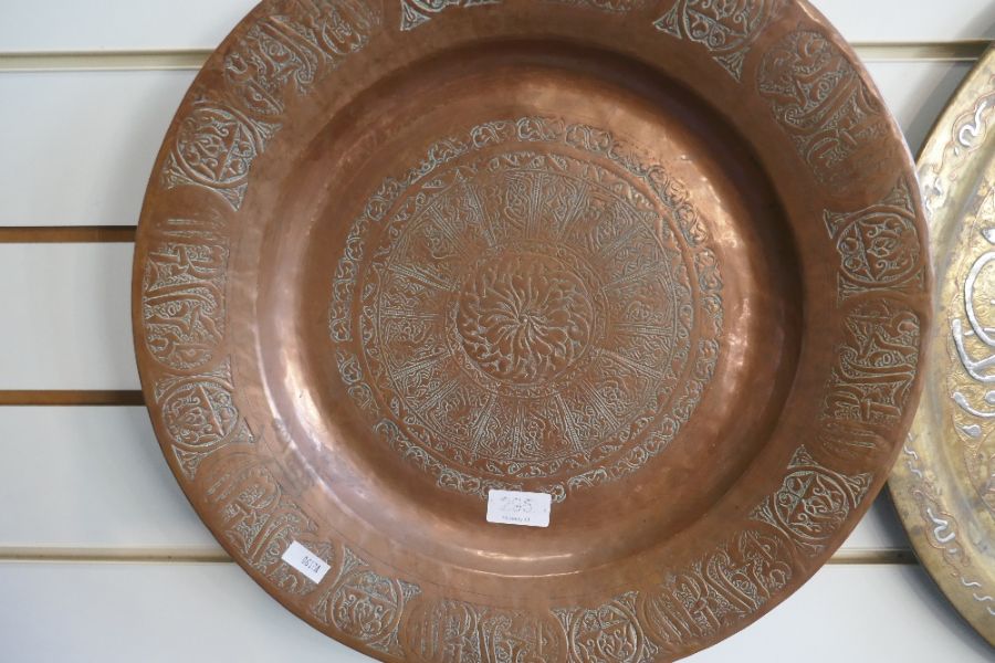 An Islamic brass circular tray with white metal lettering and one other copper example - Image 3 of 3