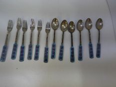 A quantity of six Korean silver teaspoons and dessert forks, having enamel handles, marked 70 silver