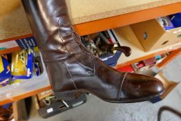 A pair of vintage brown leather riding boots and laced ankles, and two leather circular cases