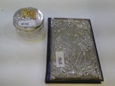 An exceptional leather address book with a decorative silver cover highlighting a romantic scene of