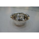 A Liberty and Co silver bowl, circular having deep rounded sides. The rim with a decorative pattern,