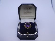 Pretty 9ct yellow gold dress ring with large central circular Amethyst in a 9ct floral design mount,