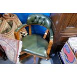 A repro green leather revolving desk chair