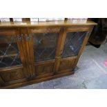 A reproduction oak bookcase having four leaded glass doors