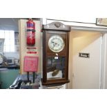 A wooden cased wall hanging pendulum clock