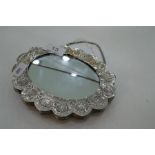 A possibly Middle Eastern mounted shaped silver mirror, having very decorative embossed back, stampe