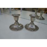 A pair of Sterling Wild Rose international candlesticks on circular bases, having embossed floral bo