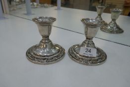 A pair of Sterling Wild Rose international candlesticks on circular bases, having embossed floral bo
