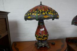 A large Tiffany style table lamp with decorated base