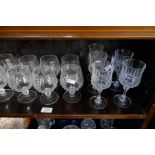 Two shelves of assorted glassware, some coloured