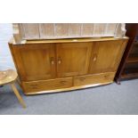 An Ercol Elm sideboard having cupboards with 2 drawers below