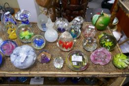 Two shelves of assorted paperweights and glass bells