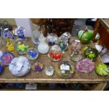 Two shelves of assorted paperweights and glass bells