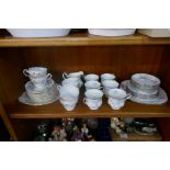 A shelf of teaware by Paragon and Royal Standard