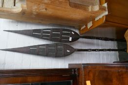A pair of 20th Century carved wooden tribal spears, having pierced decoration